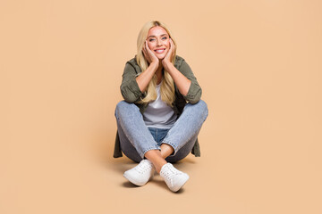 Obraz na płótnie Canvas Photo of pretty lovely cheerful lady wear comfort khaki clothes enjoy free time sitting near empty space isolated on beige color background