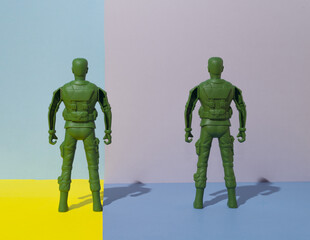 Soldiers facing the wall. Background in four colors. Combination of pastel and bright yellow....