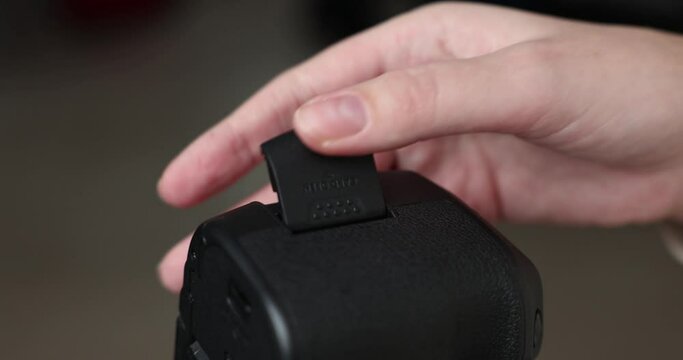 Photographer changing memory card on camera close-up of hands