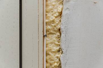 Construction mounting foam at the junction of the wall and doors