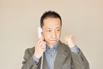 電話でやる気を出す中年サラリーマンの様子