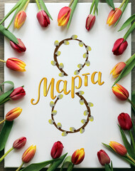 March 8 inscription in Russian on canvas decorated with red and yellow tulips. The eighth number is...
