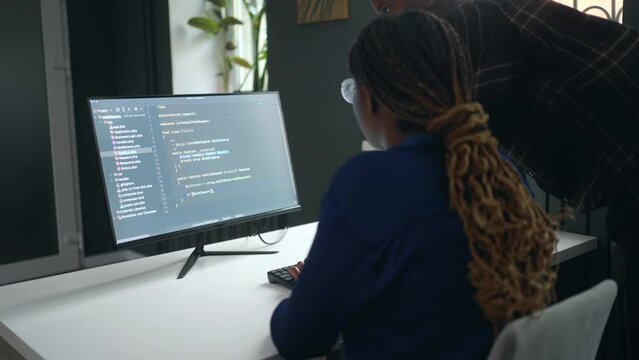 black woman data scientist working in office, man is helping her and teaching, teamwork and helping