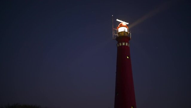 Lighthouse at night at the Frisian wadden island of Schiermonnikoog in the Dutch Waddensea region with clear light beams