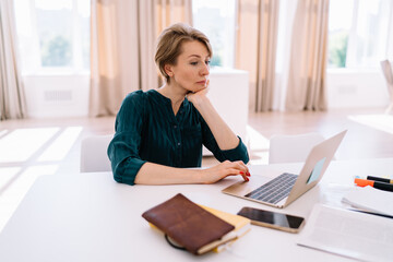 Focused businesswoman working on laptop while sitting at table