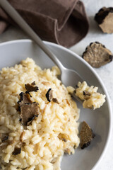 Risotto with porcini mushrooms and black truffles served in a plate top view, gourmet cousine