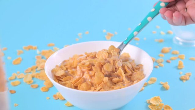 Corn flakes and milk. Sweet dry breakfast on a bright background. baby food. High quality FullHD footage