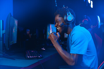 Happy American African Professional gamer, winner rejoices in victory of online games tournaments...