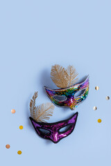 Festive face masks for masquerade or carnival celebration on colored background. Blank greeting...