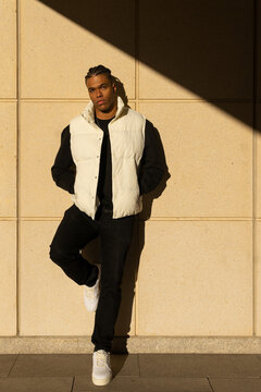 Stylish black man in trendy outfit standing on street