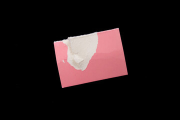 Pink torn paper piece on black background