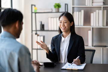 Young smart businesswoman explaining her ideas of the project to her male coworker at the office.