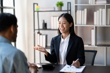 Young smart businesswoman explaining her ideas of the project to her male coworker at the office.