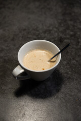 Cup of coffee with spoon on concrete table
