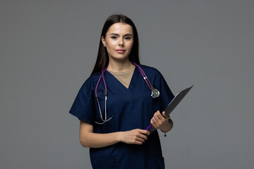 Smiling young medical doctor holding a folder isolated on white