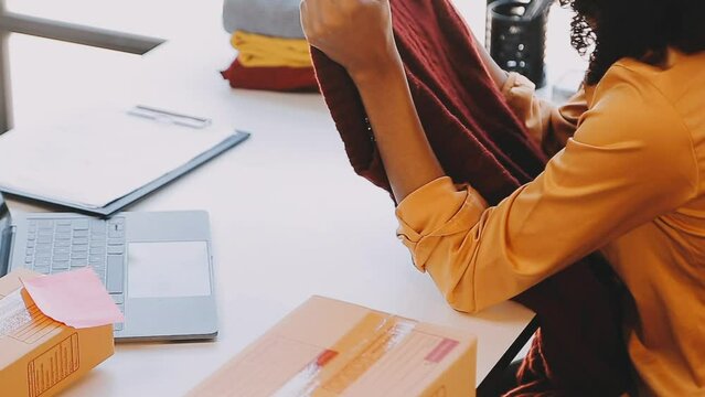 Fashion designer l young asian woman working using laptop, tablet and smiling while standing in workshop Responding on business