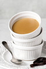 Licorice custard pudding on white plate. Front view.