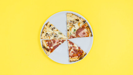 Pieces of pizza lie on a white plate. Yellow background.