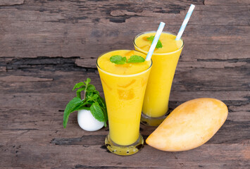 Mango juice fruit smoothies yogurt drink yellow healthy delicious taste in a glass slush for weight loss on wooden background.