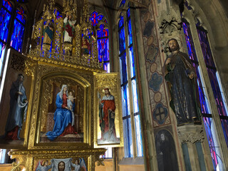 Carved saint next to a gold covered altar 