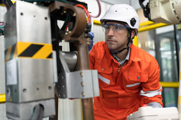 Caucasian technician engineer man use remote control with checking machine arm robot at factory	