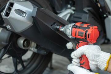 Male mechanic using motorcycle inspection tool, fixing, repairing, maintenance Vehicles to be...