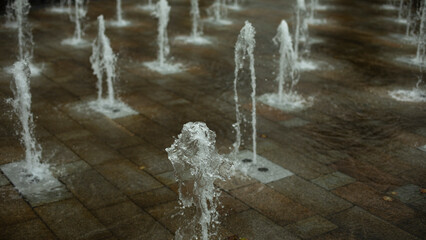 Flat fountain in city. Water jets in area. Many fountain jets.