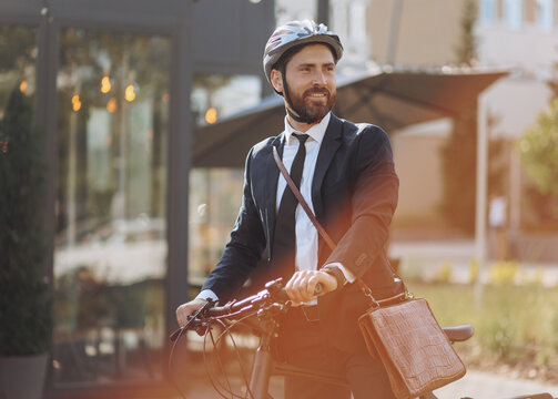 Smiling entrepreneur looking around, while resting during cycling in downtown.