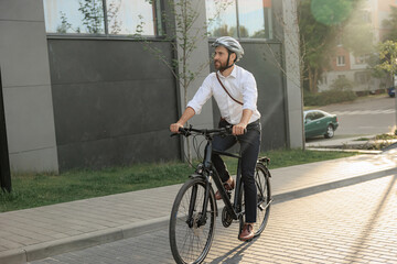 Manager wearing helmet, riding on bike, while getting to work.