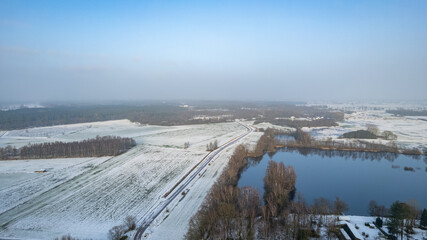 Winter frozen lake in a snowy forest top view. Frosty Christmas weather. High quality photo