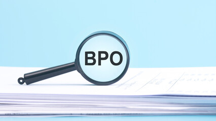 magnifying glass with BPO - Business Process Outsourcing, inscription on a blue background.