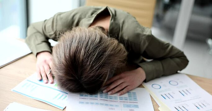 Tired businesswoman lying on table with documents with graphs 4k movie slow motio