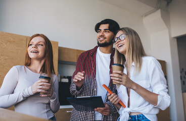 Cheerful group of coworkers standing near table