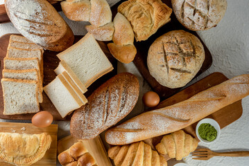Fototapeta na wymiar Mix bread kind of cereal bakery yeast white bread, pasties, buns, rye pretzel sourdough leavened tortilla and croissant on old wooden background.