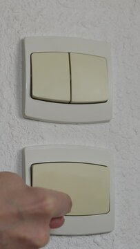 Gros plan d'un doigt sur un interrupteur &agrave; la maison - concept d'&eacute;conomie d'&eacute;nergie