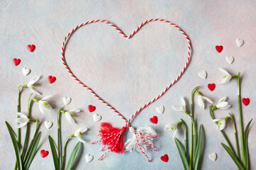 Decorative background with flowers of snowdrops, with red and white hearts, a symbol of the holiday on March 1 martenitsa, Martisor, Baba Marta, copy space. - obrazy, fototapety, plakaty