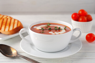 Tomato soup in a white bowl on a wooden background. Side view. copy space