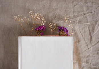 Book flat lay with dried flowers on linen background, cottagecore aesthetic