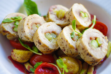 Healthy sliced asparagus stuffed chicken breast roll grilled wrap with cherry tomatoes and potato