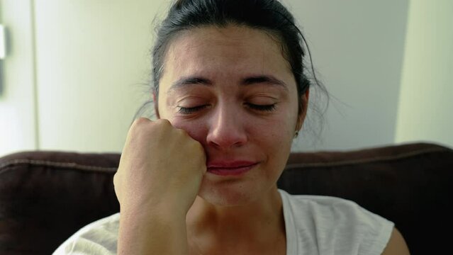 Portrait of a troubled woman crying in despair during hard times. Closeup face of a person feeling anxiety and hopelessness. Real authentic emotion
