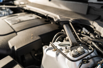 Shallow focus of an engine supporting strut seen in the engine bay of a luxury SUV. A pair of bolts fix the strut to the vehicle sub frame.