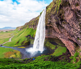 Obraz premium Charming beautiful waterfall Seljalandsfoss in Iceland. Exotic countries. Amazing places. Popular tourist atraction.