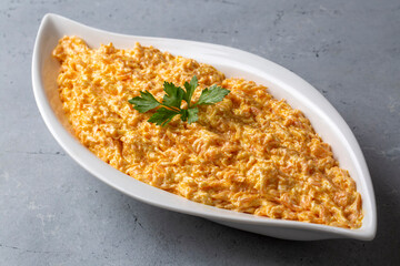 Traditional delicious Turkish foods; Fresh carrot salad with garlic yogurt in bowl. ( Turkish name; havuc tarator) Carrot tarator in ceramic bowl with vegetable on dark background.