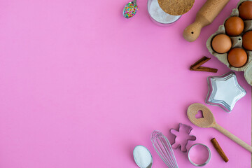 Baking tools and ingredients background with copy space. Pink wallpaper with sugar, spoons, whisk and cookie cutters. homemade dessert concept.