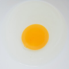 Uncooked yolk egg on white background. Chicken raw egg. Fresh food.Top view of yellow egg. White and yellow colors, food photography. Uncooked egg concept