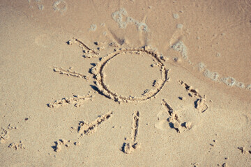 Shape of sun and incoming sea wave on sand at beach. Travel and vacation time