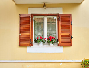 A wooden window with potted bright violet colored cyclamen flowers. Travel to Athens, Greece.