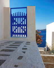 A picturesque blue door and crystal clear blue sky as a background. Travel to Milos island, Greece.