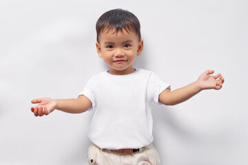 Excited Toddler Asian kid boy 2 years old wearing a white t-shirt raising a fist, celebrating success isolated on white background