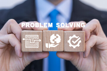 Businessman holding wooden cubes with icons and sees inscription: PROBLEM SOLVING. Concept of...